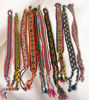 Vibrant handmade bracelets made from Peruvian manta fabric, displayed on white cloth, featuring unique Inca patterns.