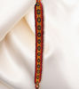 Colorful handmade bracelet on white cloth, showcasing Inca designs and adjustable for stacking style.