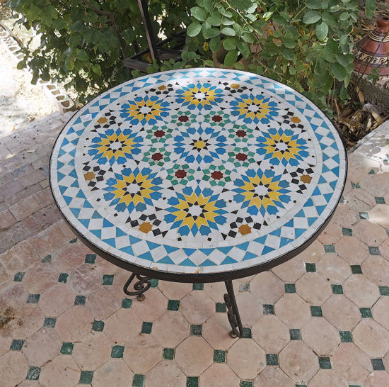 Colorful mosaic coffee table with a flower pattern on a patio, showcasing Moroccan craftsmanship and mid-century design.