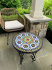A colorful Moroccan mosaic table on a patio, showcasing intricate patterns and vibrant tiles, perfect for indoor or outdoor use.