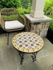 Colorful Moroccan mosaic coffee table on a stone floor, showcasing intricate geometric patterns and vibrant tile designs.