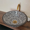 Handcrafted black-and-white ceramic sink with a gold faucet, blending Moroccan artistry and modern elegance for any bathroom.