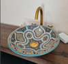 Boho-style bathroom featuring a handmade Moroccan ceramic vessel sink with mid-century design on a wooden vanity top.
