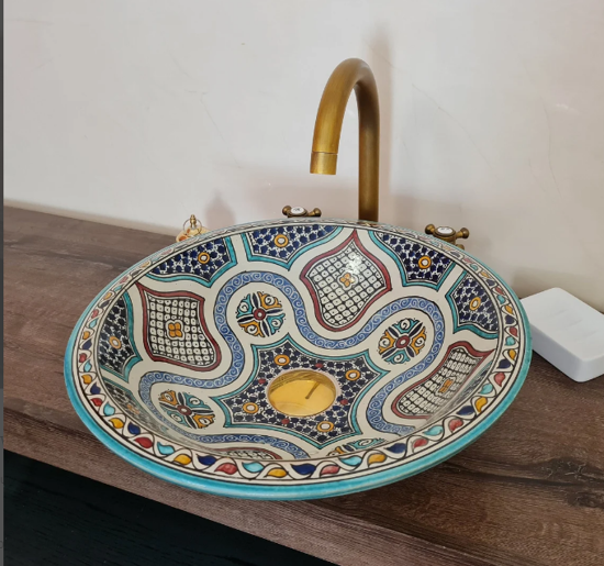 Boho-style bathroom featuring a handmade Moroccan ceramic vessel sink with mid-century design on a wooden vanity top.