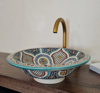 Vibrant Moroccan ceramic sink displayed on a wooden table, highlighting its unique boho design and mid-century modern charm.