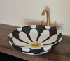 Black and white ceramic vessel sink with a gold faucet, showcasing intricate Moroccan hand-painted designs and craftsmanship.