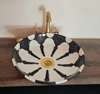 Elegant black and white bowl sink featuring a gold faucet, highlighting unique Moroccan artistry and durable ceramic construction.