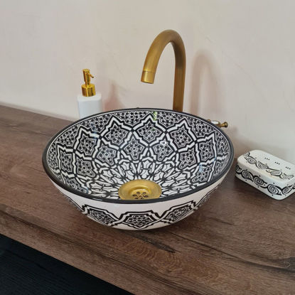 Handmade black and white Moroccan wash basin with intricate patterns and a gold faucet, showcasing Mediterranean elegance.