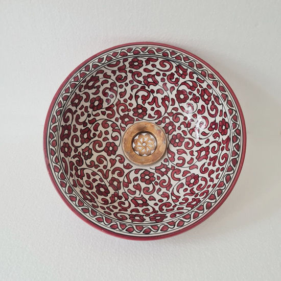A decorative red and white bowl adorned with floral motifs, exemplifying Moroccan ceramic artistry and mid-century design.