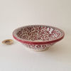 Elegant bowl-shaped sink featuring a gold and red pattern, blending traditional Moroccan craftsmanship with modern design.