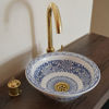 Elegant blue and white ceramic sink with a gold handle, featuring unique Moroccan patterns, perfect for bathroom installation.