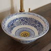Artisan-crafted blue and white bowl sink with a gold handle, highlighting traditional Moroccan artistry for stylish bathroom decor.