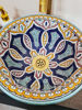 Handmade Moroccan ceramic bowl with colorful patterns, placed on a wooden counter, highlighting its Mediterranean artistry.
