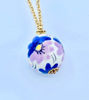 Picture of Hand molded and hand painted ceramic sphere pendant. Gold plated brass chain