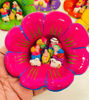 Handcrafted flower-shaped dishes display colorful figures in a vintage Peruvian nativity scene, highlighting traditional folk art.