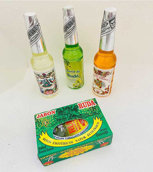 Three perfume bottles in various scents alongside a box of spiritual bar soap, representing a blend of fragrance and ritual elements.