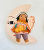 Handmade ceramic figurine of an angel on a moon, showcasing Peruvian artistry in holiday decor.