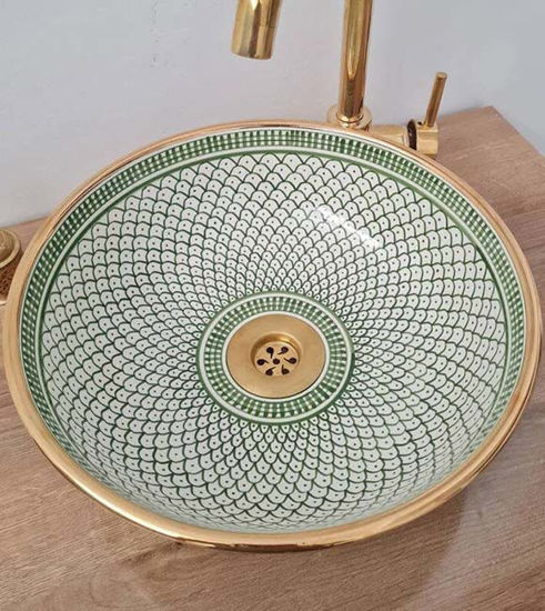 Handmade Moroccan bathroom sink in green and gold, featuring a gold faucet and intricate fish scale design.