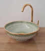 Luxurious green and gold ceramic sink with a gold faucet, showcasing a unique fish scale pattern, handcrafted in Morocco.