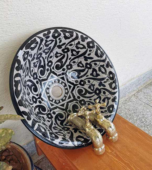 Black and white ceramic basin sink with gold faucets, showcasing Moroccan craftsmanship and unique artistry.