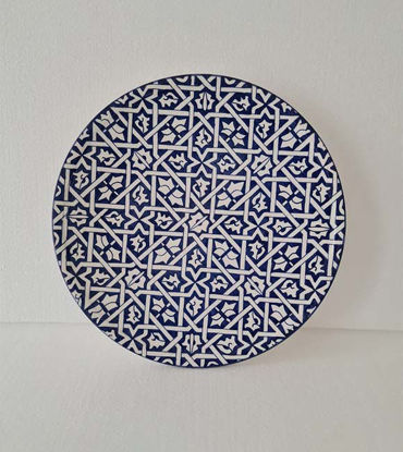 A 14-inch blue and white Moroccan ceramic wall plate featuring intricate geometric designs, showcasing traditional craftsmanship.