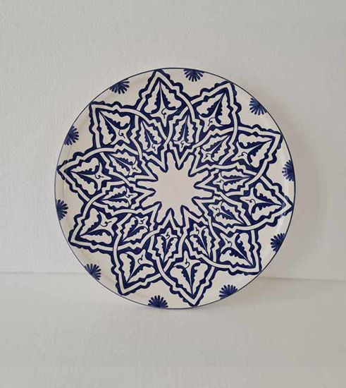 A 14-inch handmade Moroccan ceramic plate in blue and white, featuring intricate hand-painted designs and a glossy finish.