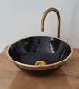 Handmade black ceramic sink with a brushed brass faucet, reflecting Moroccan artistry and unique, intricate designs.