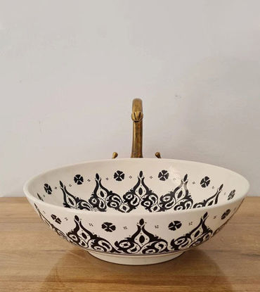 Black and white Moroccan ceramic sink with a gold handle, showcasing mid-century modern design and intricate patterns.