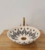 Elegant black and white ceramic wash basin featuring a gold handle, handcrafted in Morocco with mid-century modern flair.