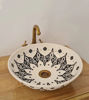 Hand-painted black and white Moroccan sink with a gold handle, embodying mid-century modern style and unique artistry.