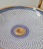 Close-up of blue and white porcelain bowl featuring a gold rim, designed as a luxurious Moroccan vessel sink for bathrooms.