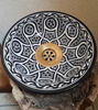 Elegant black and white ceramic vessel sink with a gold handle, featuring intricate hand-painted designs inspired by Moroccan art.