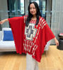 A woman in a flowing red poncho, embodying the cultural pride and bohemian spirit of the Wildflower Breeze Kaftan top.