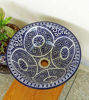 Blue and white ceramic bowl on a wooden table, showcasing intricate Moroccan patterns and a brushed brass rim.