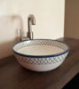 Handcrafted blue and white ceramic washbasin with intricate patterns, showcasing Mediterranean charm and artisan craftsmanship.