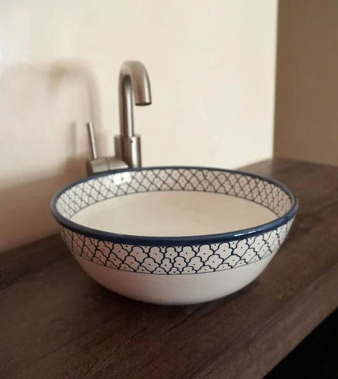 Handcrafted blue and white ceramic washbasin with intricate patterns, showcasing Mediterranean charm and artisan craftsmanship.