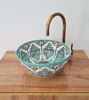 Unique bucket-shaped sink with a green and white design, handcrafted in Morocco, adding artistic flair to any bathroom.