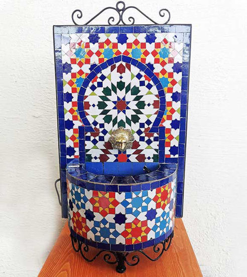 Handmade Moroccan wall fountain with vibrant mosaic tiles, designed for indoor or outdoor use, featuring a calming water flow.