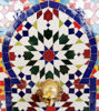 Rustic outdoor wall fountain with colorful mosaic tiles, blending traditional Moroccan artistry