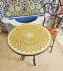 Round golden mosaic table with intricate designs showcasing Moroccan craftsmanship and mid-century style.