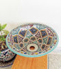 Colorful handpainted Moroccan ceramic sink bowl on a wooden table, showcasing intricate designs and vibrant motifs.