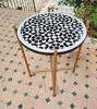 Black and white mosaic coffee table with a golden base, showcasing intricate geometric patterns, handcrafted in Morocco.