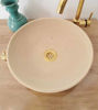 Round Raw Beige Clay Bathroom Sink set atop a wooden countertop
