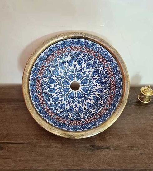 Elegant blue and white ceramic bowl featuring a gold handle, perfect for a mid-century or antique bathroom sink.