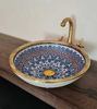 Elegant blue and white porcelain sink featuring a gold faucet and brushed brass rim, ideal for vintage-inspired bathrooms.