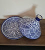 Large blue and white ceramic tagine pot on a wooden table, highlighting traditional Moroccan craftsmanship and design.