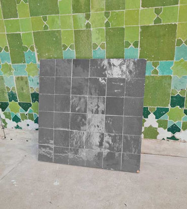 Handmade Moroccan Zellige tile featuring a soft light gray glaze with a unique lava-like texture, ideal for various interiors.