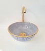 Handmade Moroccan ceramic bowl in blue and white, featuring golden trim and unique patterns, perfect for bathroom decor.