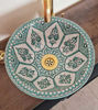 A handcrafted mint green Moroccan ceramic sink rests on a wooden counter, showcasing intricate patterns and mid-century modern style.