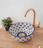 Vibrant blue and white bowl with sunflower patterns, handcrafted by Moroccan artisans, perfect for a stylish bathroom sink.